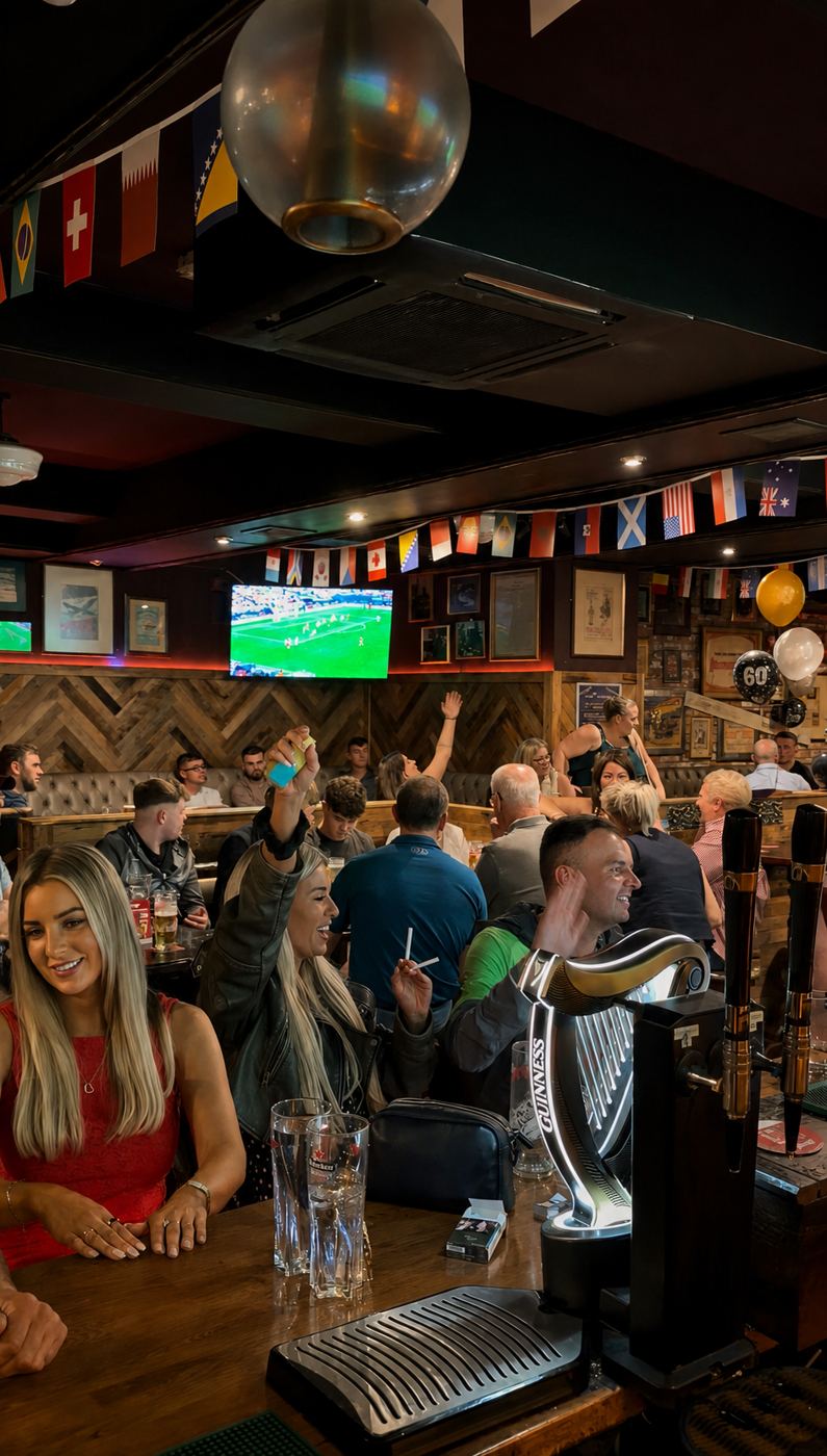 A packed bar cheering a match on the big screen